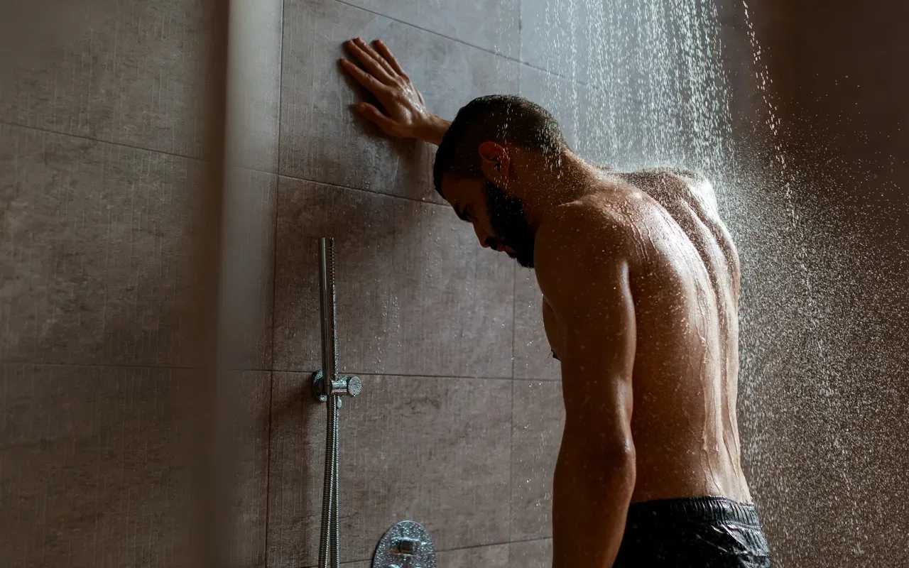 homme qui se penche sur le mur prend une douche