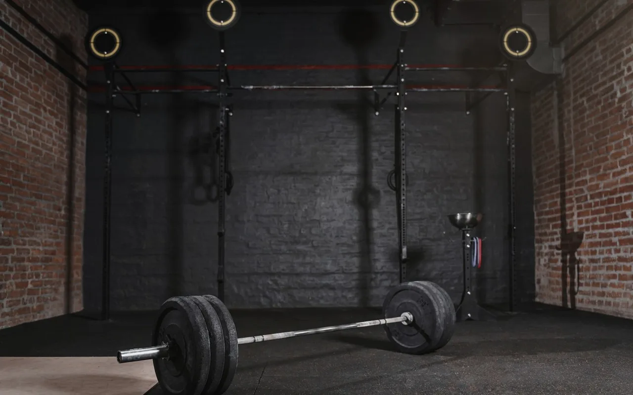 Salle de crossfit vide avec une barre sur le sol