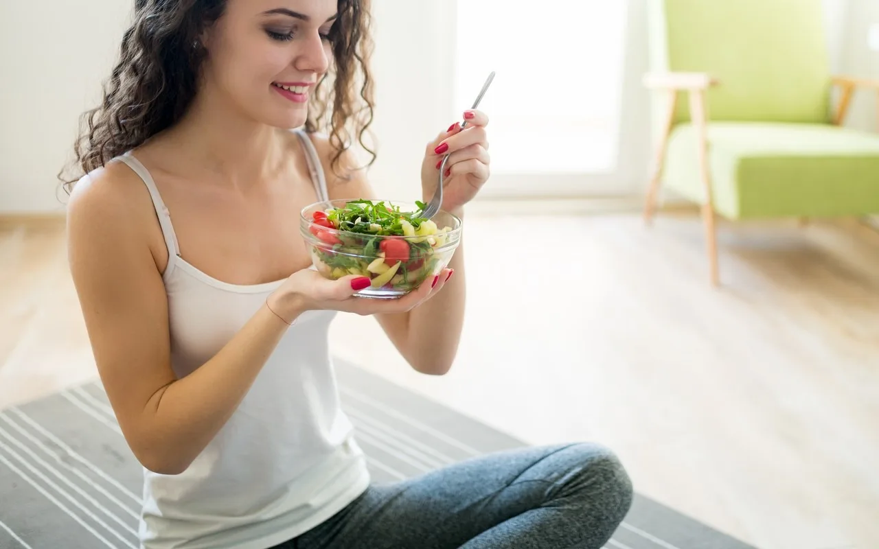 femme assise qui mange avant sa séance de sport