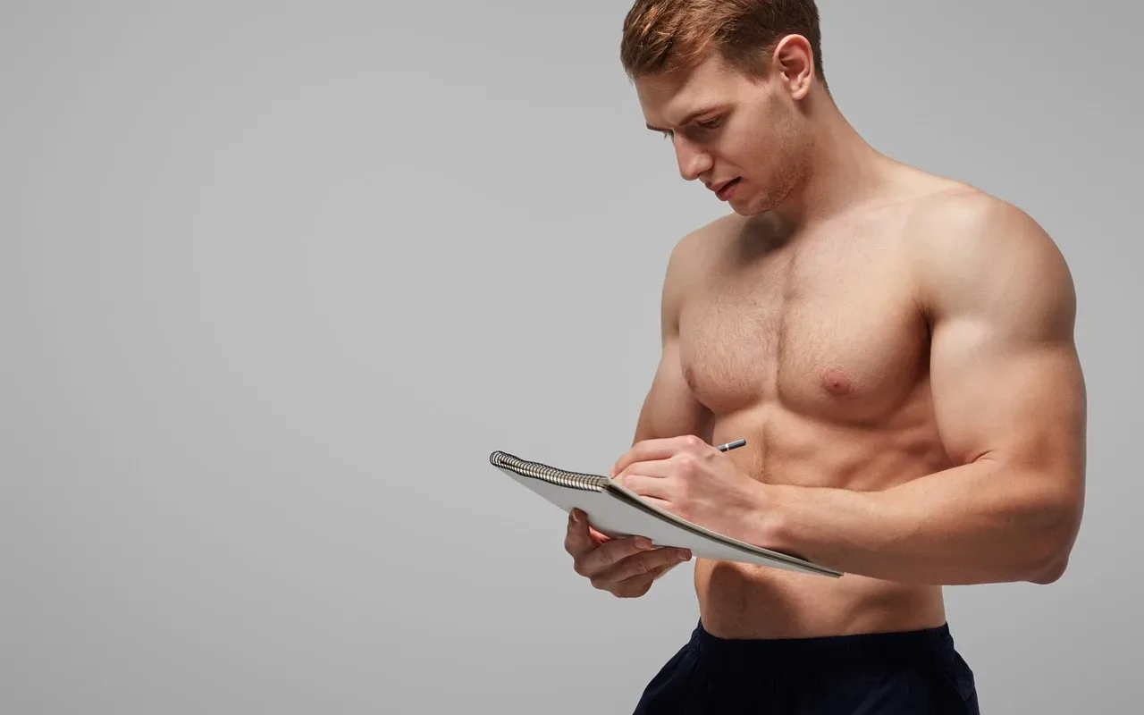 Homme musclé qui prends des notes