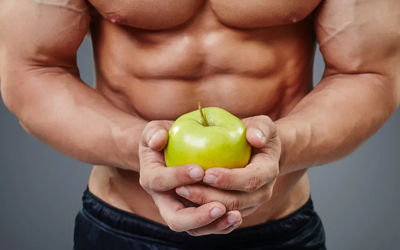 homme musclé avec une pomme