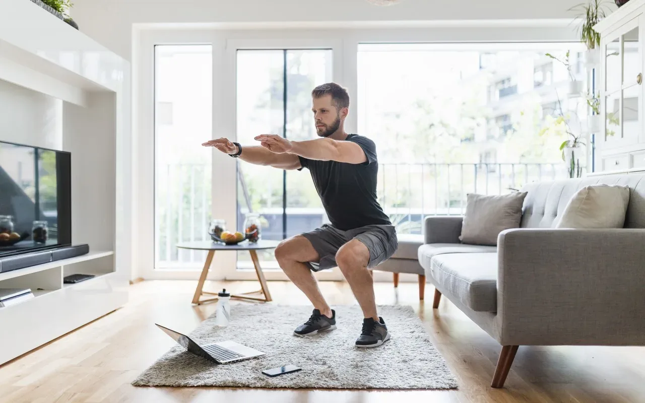 homme qui fais des squats chez lui