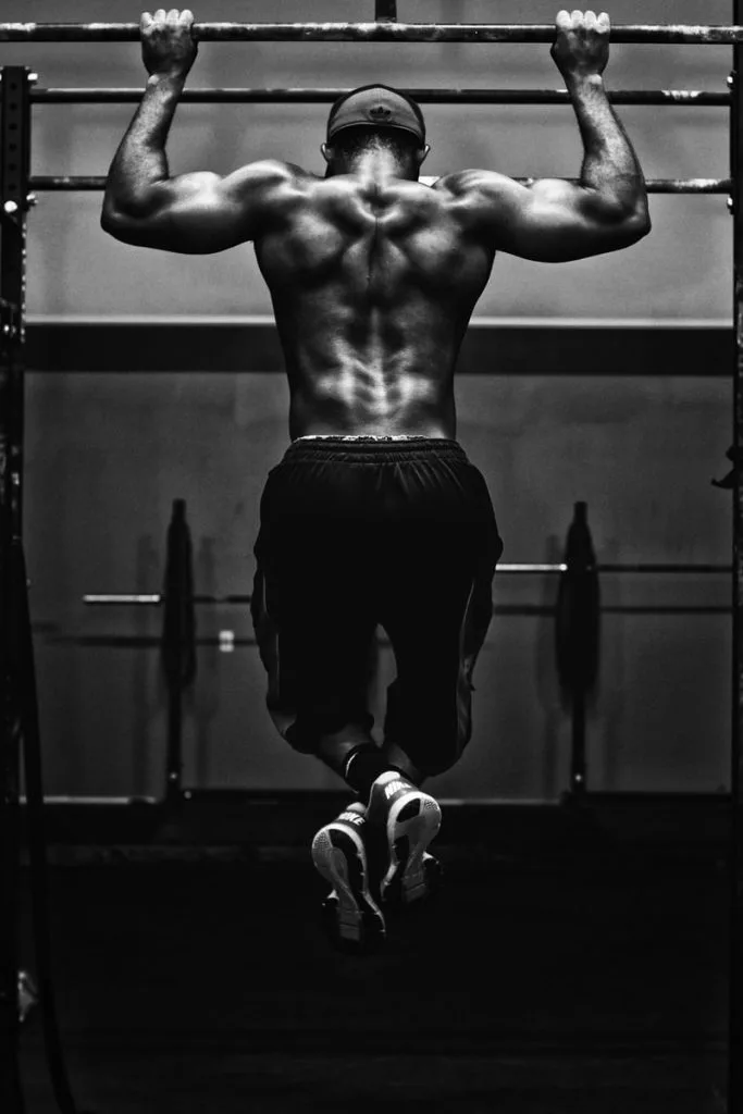 Photo en noir et blanc d'un homme musclé faisant une traction
