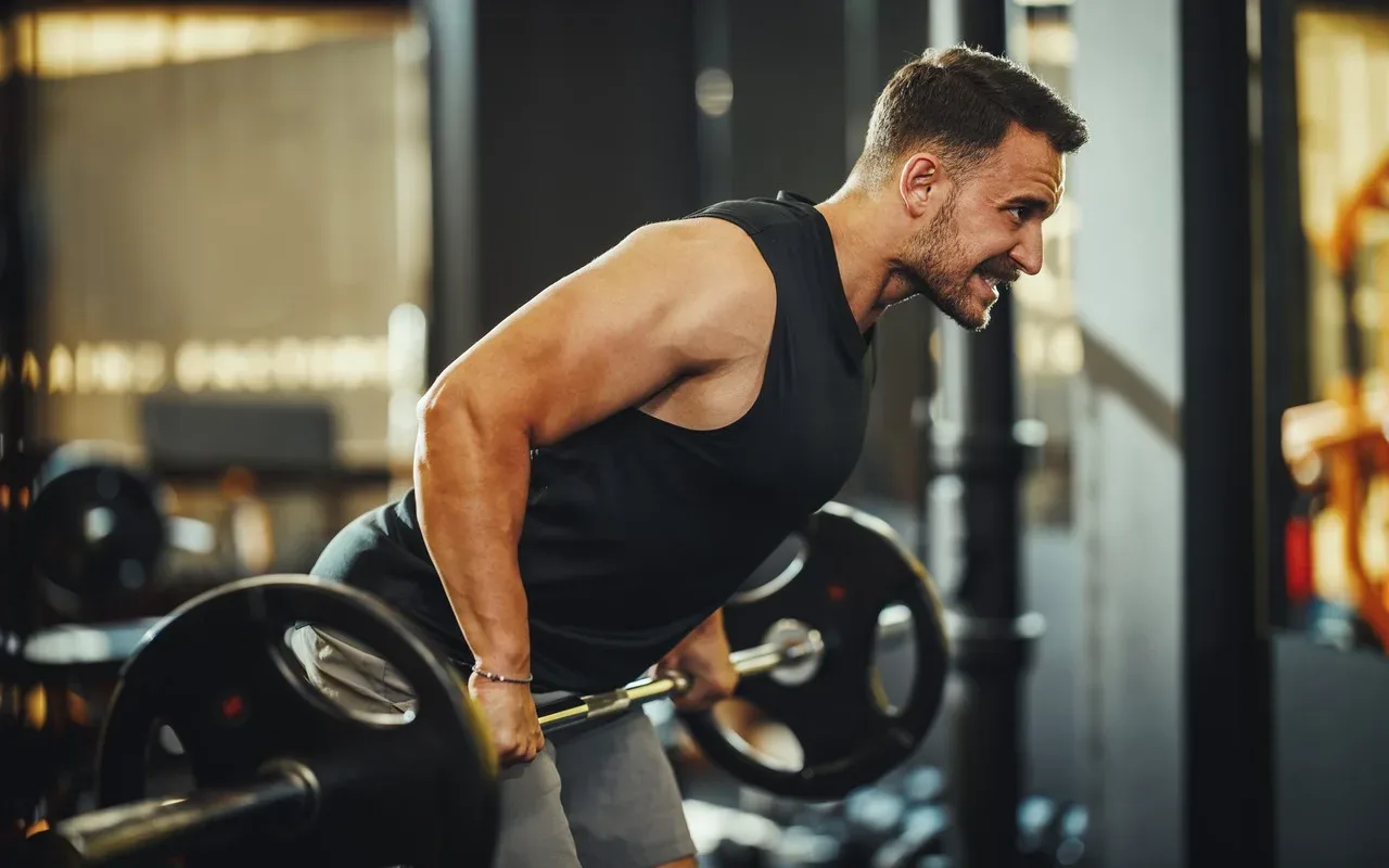 homme qui fais du rowing à la barre , de manière intense