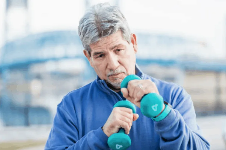 Un homme senior effectue des exercices avec des haltères.