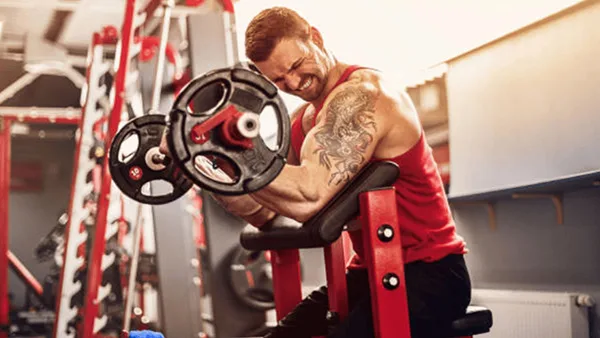 Un athlète effectuant un curl biceps avec une barre.